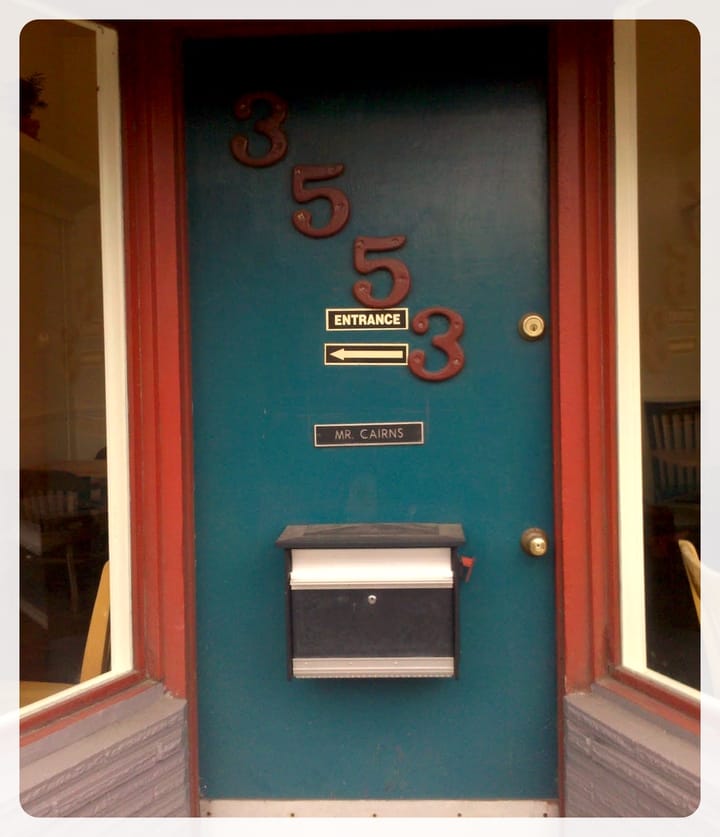 An outside door with an arrow indicating the entrance is to the left and a name plate with "Mr. Cairns" 